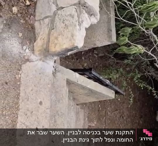 מעקה מתכת שחור מותקן לצד מדרגות אבן בגינה